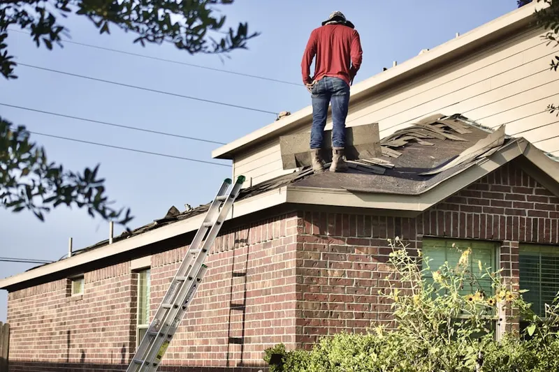 Professional roofer working on a residential roof in Purchase Line